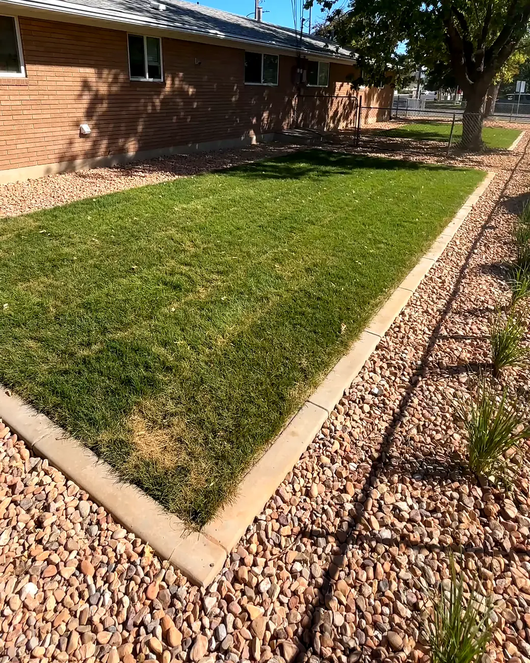 Finished yard with new sod, concrete curbing and rock beds