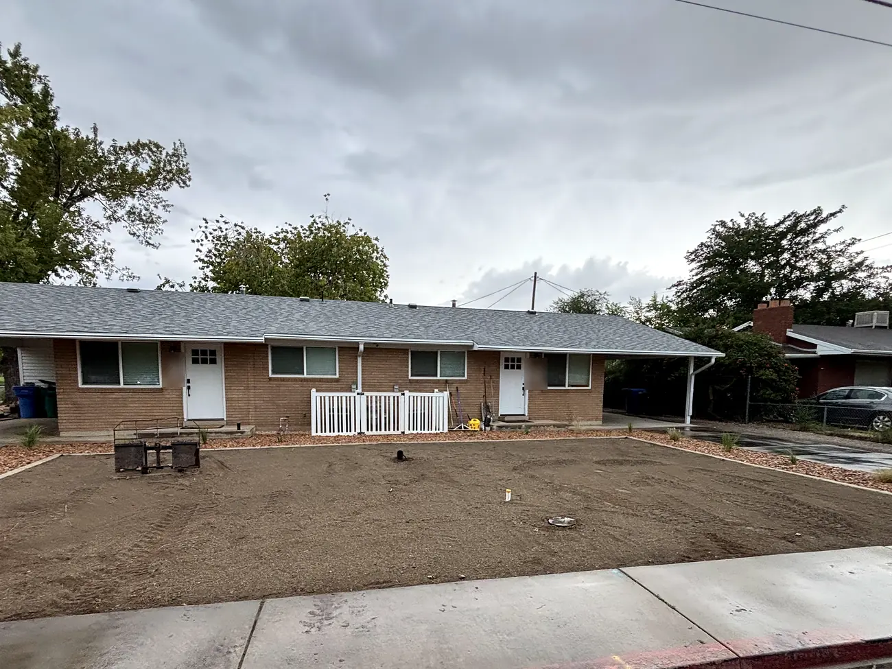Front yard graded and ready for sod inside new curbing, with rock beds along the house
