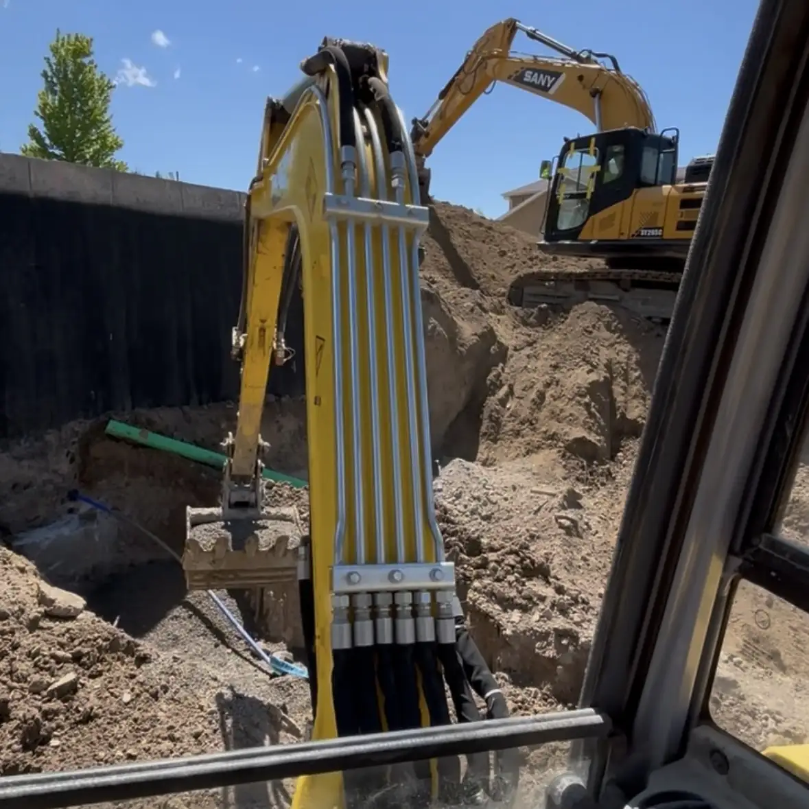 View from an excavator cab digging a deep residential excavation