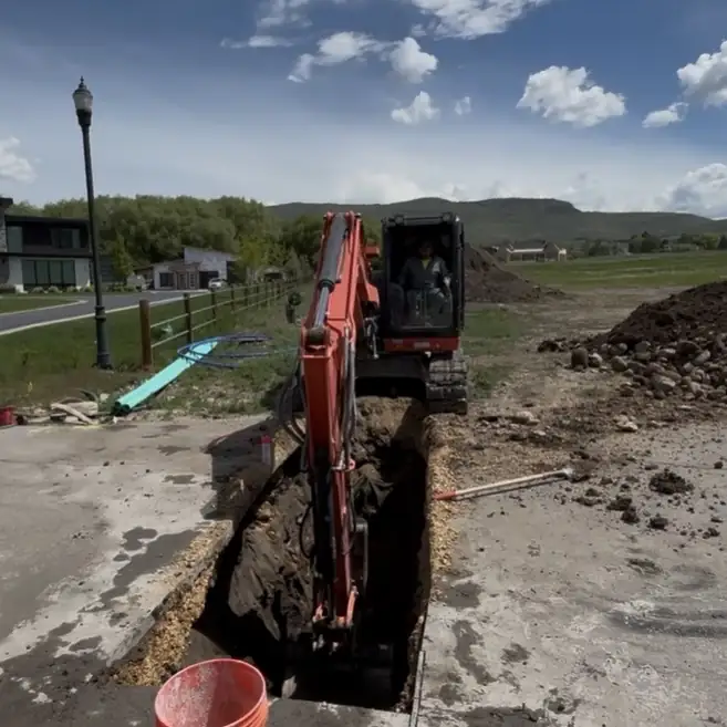 Excavator digging a trench at a new home site