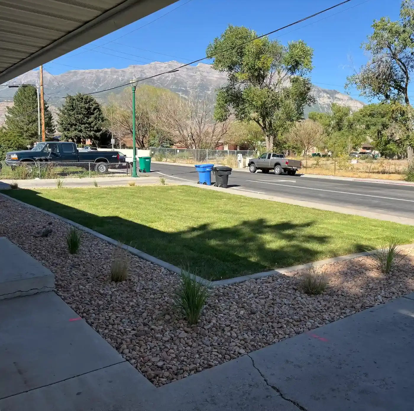 Front yard with new sod, rock borders and ornamental grasses below the Wasatch mountains